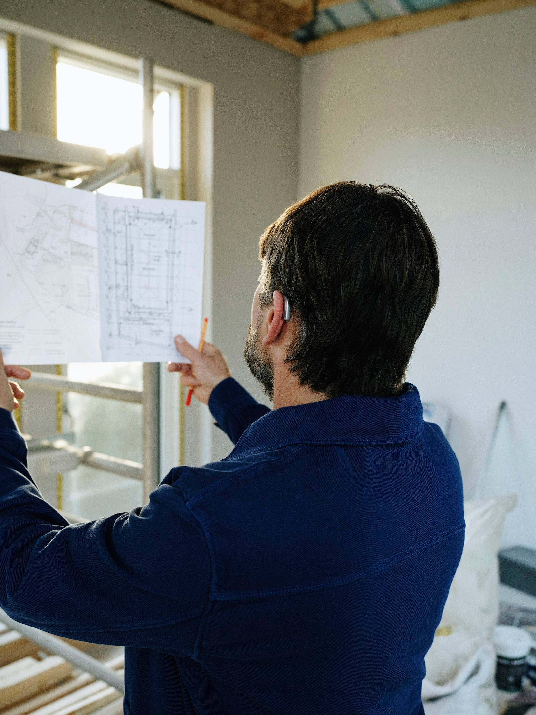 Engineer reviewing mechanical drawings on site